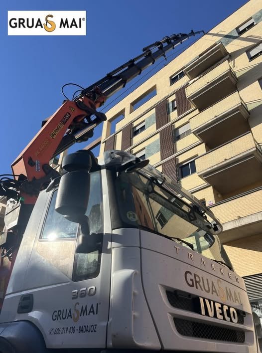 Camión pluma de Grúas MAI elevando hasta la última planta de un edificio en Badajoz